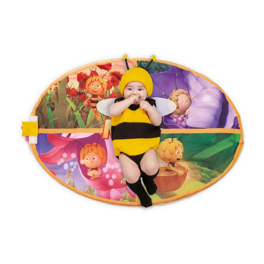 En glad bebis ligger på den utfällda bi-dräkten, som förvandlats till en lekmatta med motiv från Maya the Bee.