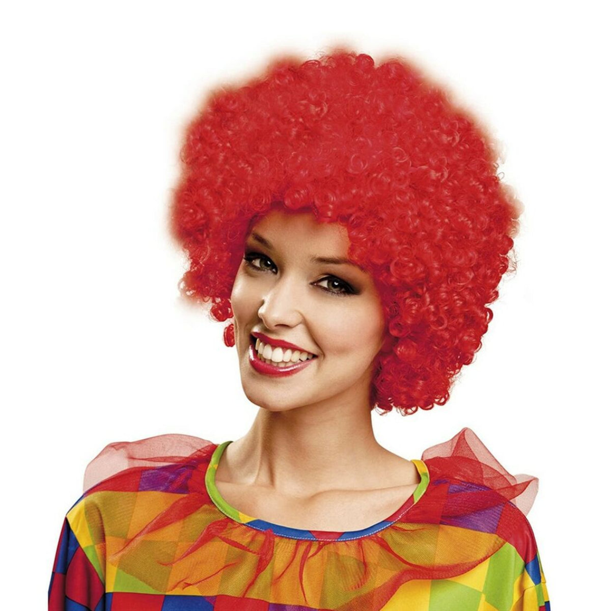En leende kvinna i en färgglad clowndräkt bär en stor, yvig och superkrullig peruk i en intensiv, eldröd färg.