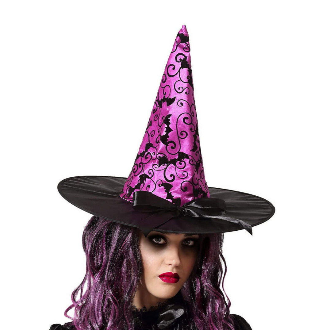 En kvinna med mörkt smink bär en Elegant Rosa Häxhatt med ett mönster av svarta fladdermöss och en svart rosett.