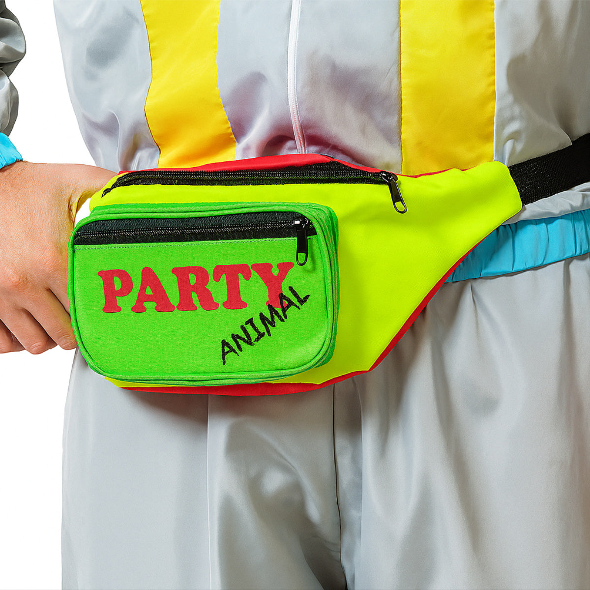 En person klädd i en 80-tals tracksuit bär en färgglad magväska i neonfärger med texten 'PARTY ANIMAL' på den gröna framfickan.
