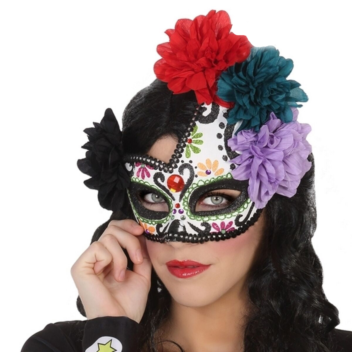 En kvinna med en intensiv blick bär en vacker, vit Day of the Dead-ögonmask dekorerad med svarta mönster, glitter och en stor krans av färgglada tygblommor.