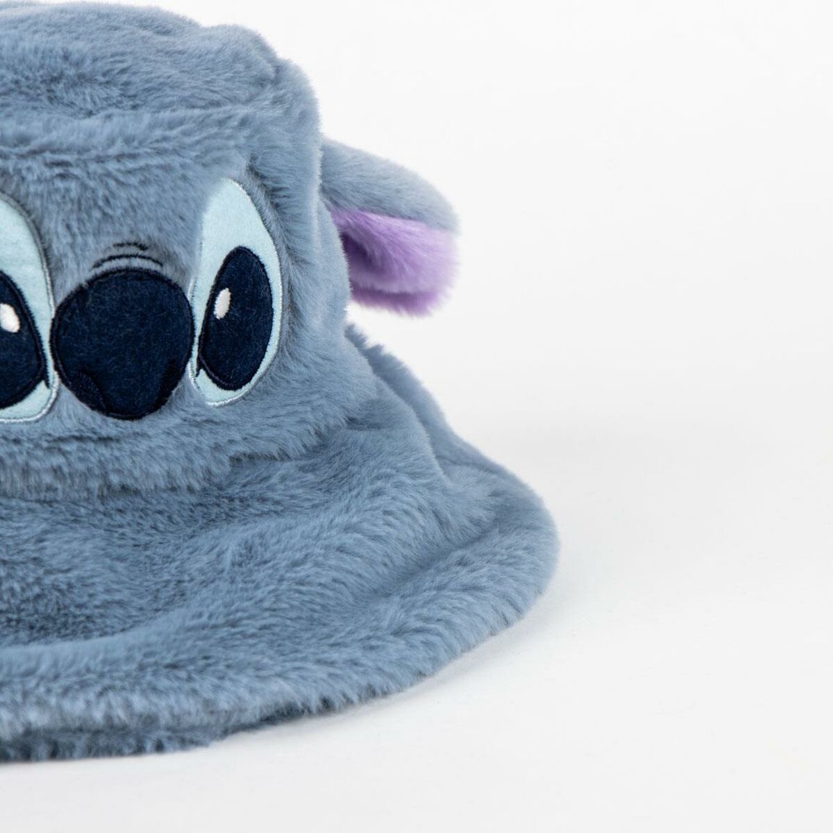 En närbild på ett av de fluffiga, blåa ögonen med en lila insida på Stitch-hatten.