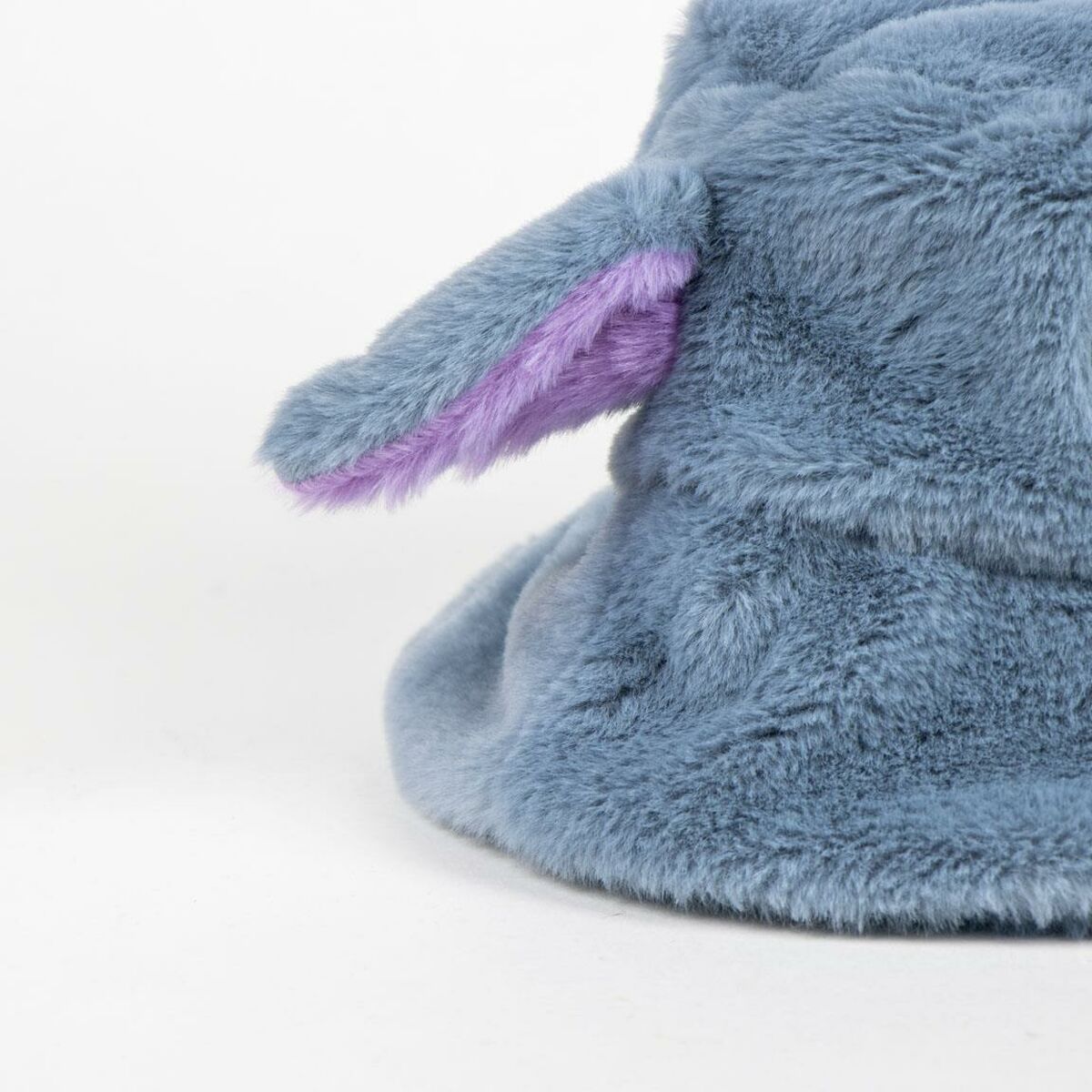 En närbild på ett av de fluffiga, blåa öronen med en lila insida på Stitch-hatten.