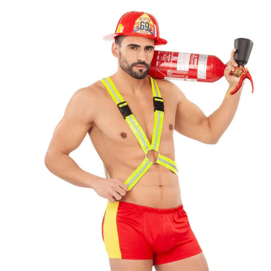 En muskulös man poserar i en Glödhet Brandman Maskeraddräkt, bestående av röda hotpants, en reflexsele och en brandmanshatt, och håller en brandsläckare över axeln.