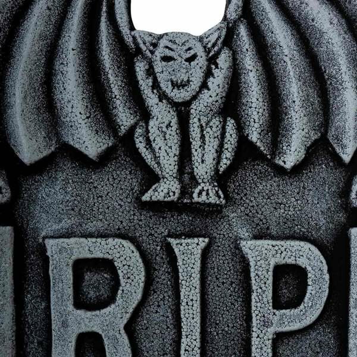 En närbild på den övre delen av gravstenen, som fokuserar på den detaljerade gargoylen och R.I.P.-texten.