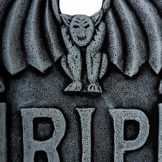 En närbild på den övre delen av gravstenen, som fokuserar på den detaljerade gargoylen och R.I.P.-texten.