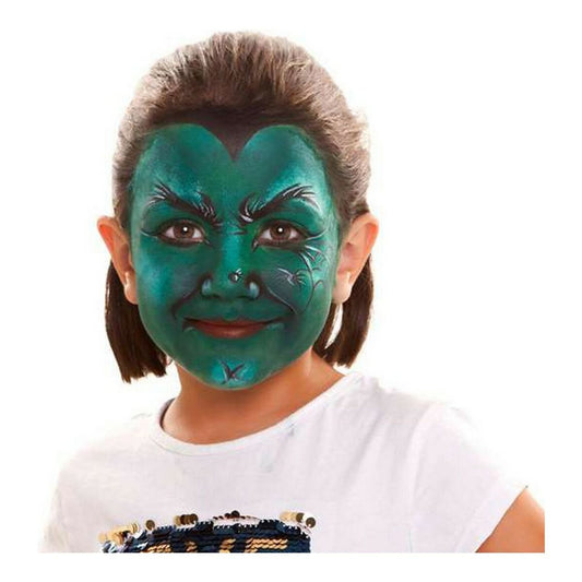 Ett barn med en imponerande grön ansiktsmålning som en häxa, med mörka detaljer och skuggningar, ler mot kameran.