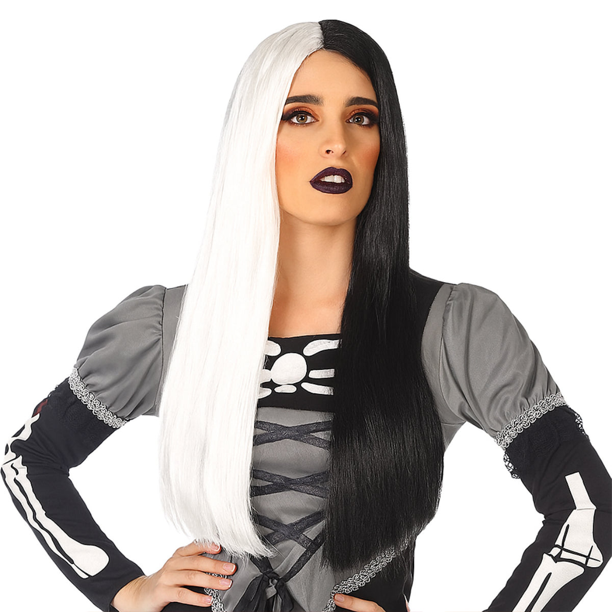 Kvinna med lång peruk i två färger – ena sidan vit, andra svart, mittbena och rakt hår. Bär grå klänning med skelettmönster.