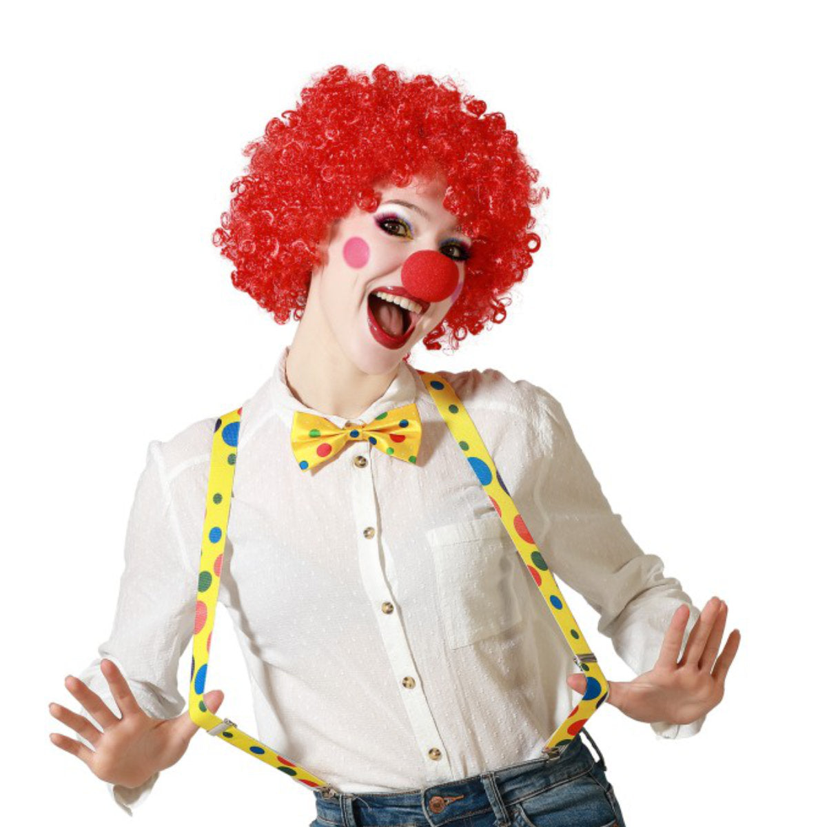 En glad kvinna utklädd till clown, med en röd peruk, röd näsa och ett kit med gula, prickiga hängslen och fluga.
