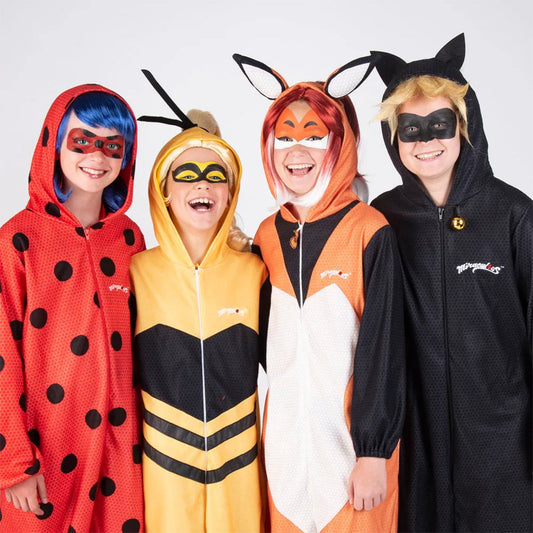 Fyra glada barn utklädda till karaktärerna från Miraculous, med detaljerade ansiktsmålningar som matchar deras dräkter.