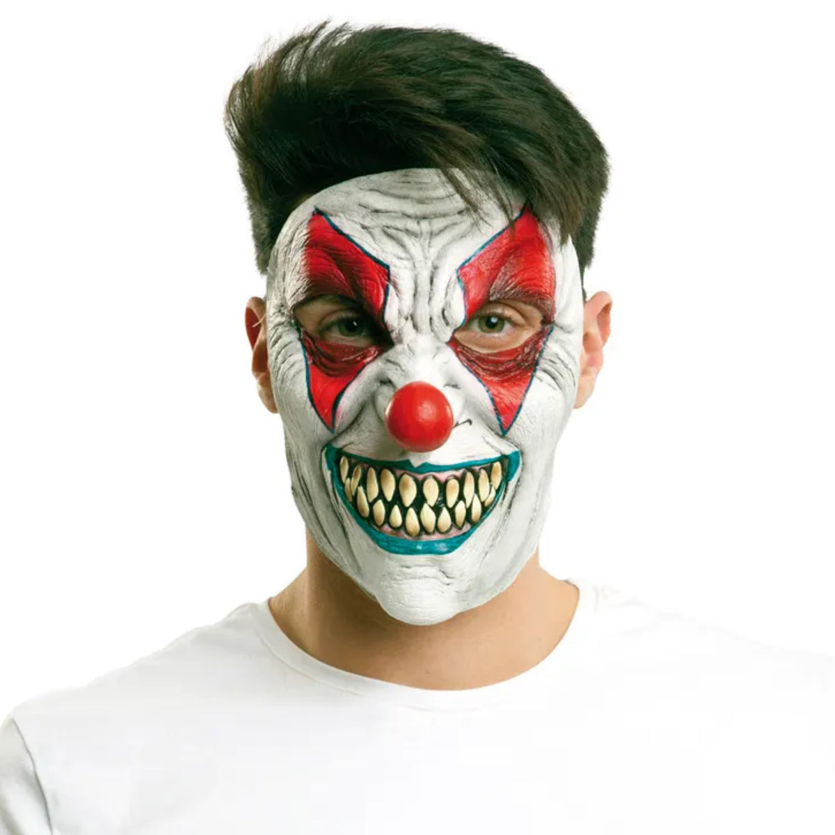 En man stirrar intensivt in i kameran medan han bär en skrämmande vit clownmask med ett brett, tandfyllt leende, röda detaljer och en röd näsa, mot en vit bakgrund.