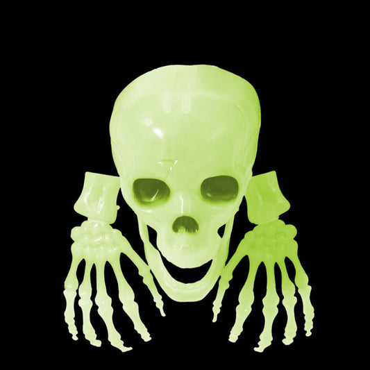Ett självlysande kit med en dödskalle och två händer som glöder med ett kusligt grönt sken i mörkret.