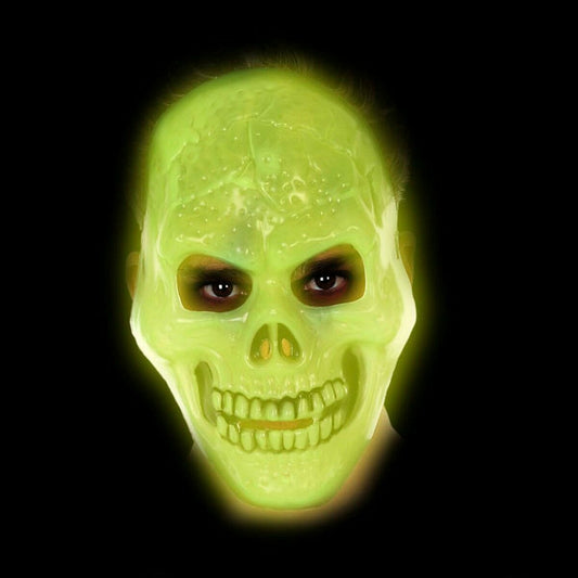 Den självlysande dödskallemasken glöder med ett intensivt, grönt sken i mörkret.