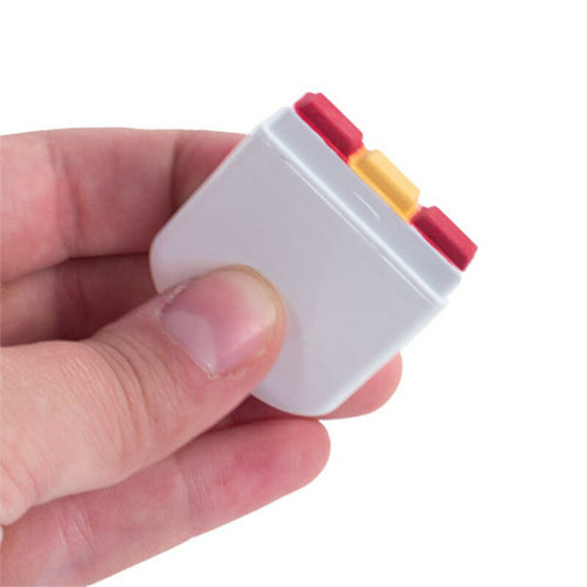 Hand som håller sminkstift med tre färger mot vit bakgrund.