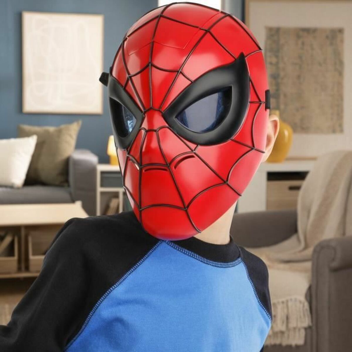 Ett barn bär den röda Spider-Man-masken i profil i ett vardagsrum.