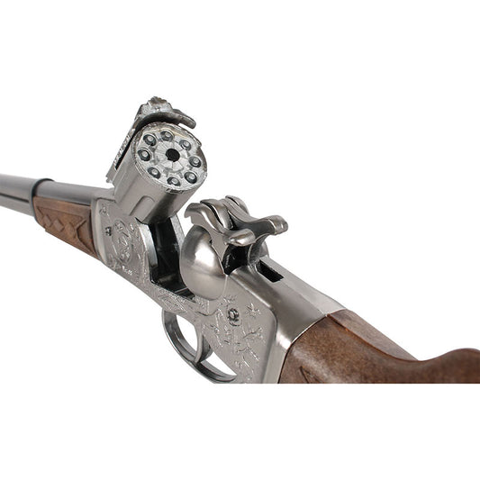 Detaljerad närbild på ett silverfärgat westerngevär i metall och träimitation, med fokus på den öppna trumman för 8-skotts knallpulver.