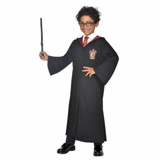 Ett glatt barn med lockigt hår och runda glasögon iklädd en svart Harry Potter-inspirerad trollkarlskåpa, håller en tryllstav.