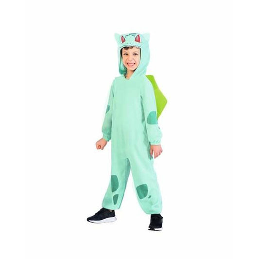 Ett leende barn står i en mintgrön helkroppsdräkt föreställande Pokémon-figuren Bulbasaur, komplett med huva och ryggdetalj.