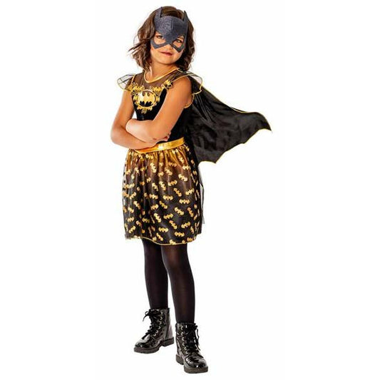 Ett ungt barn i en svart och guld Batgirl maskeraddräkt med en matchande svart mask och en flygande cape.