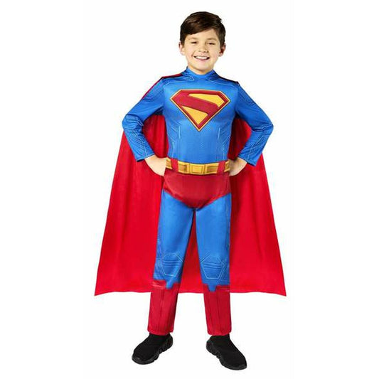 Ett glatt barn i en komplett Superman-maskeraddräkt med blå dräkt, rött och gult S-emblem, gyllene bälte och en stor röd mantel.