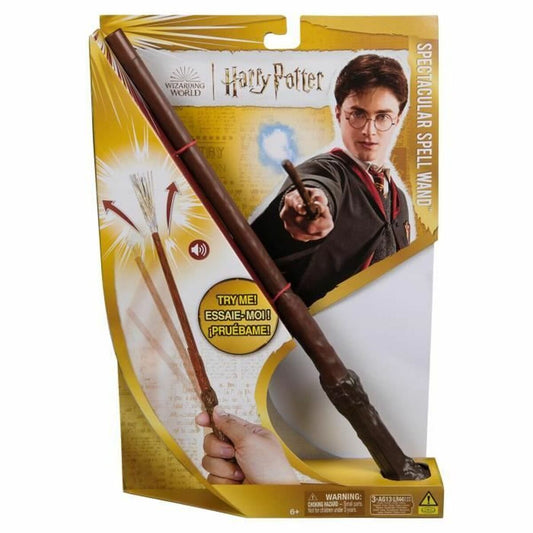 En person håller i en mörkbrun Harry Potter trollstav i sin förpackning, där det visas att trollstaven har en kvast-liknande effekt och ljudeffekter.