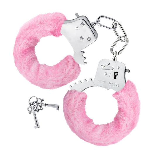 Ett par silverfärgade handbojor fodrade med tjockt, ljust rosa fluff, kopplade med en kort kedja, med två små nycklar liggande bredvid.