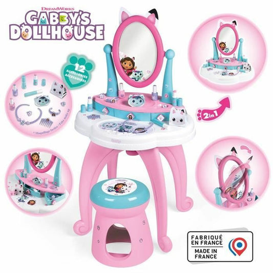 Ett rosa och turkost sminkbord för barn med Gabby's Dollhouse tema, inklusive en spegel med kattöron, pall och 12 olika sminkaccessoarer.