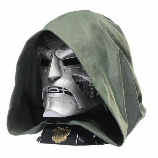 Närbild på en silvrig, nitad mask som liknar Doctor Doom, draperad under en stor, mörkgrön tyghuva.