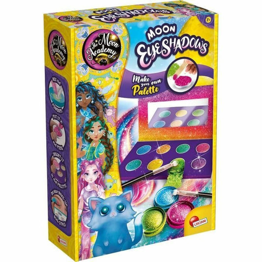En färgglad kartongförpackning för ett pysselkit som heter 'Moon Eyeshadows' från The Moon Academy, som visar instruktioner för att blanda egna ögonskuggor och en blå kattkaraktär.