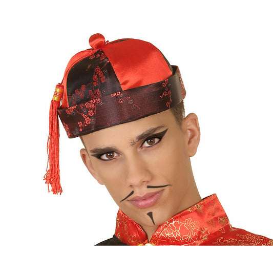 En ung man bär en röd och svart orientalisk dräkthatt med en röd tofs som hänger ner vid sidan av hans huvud.