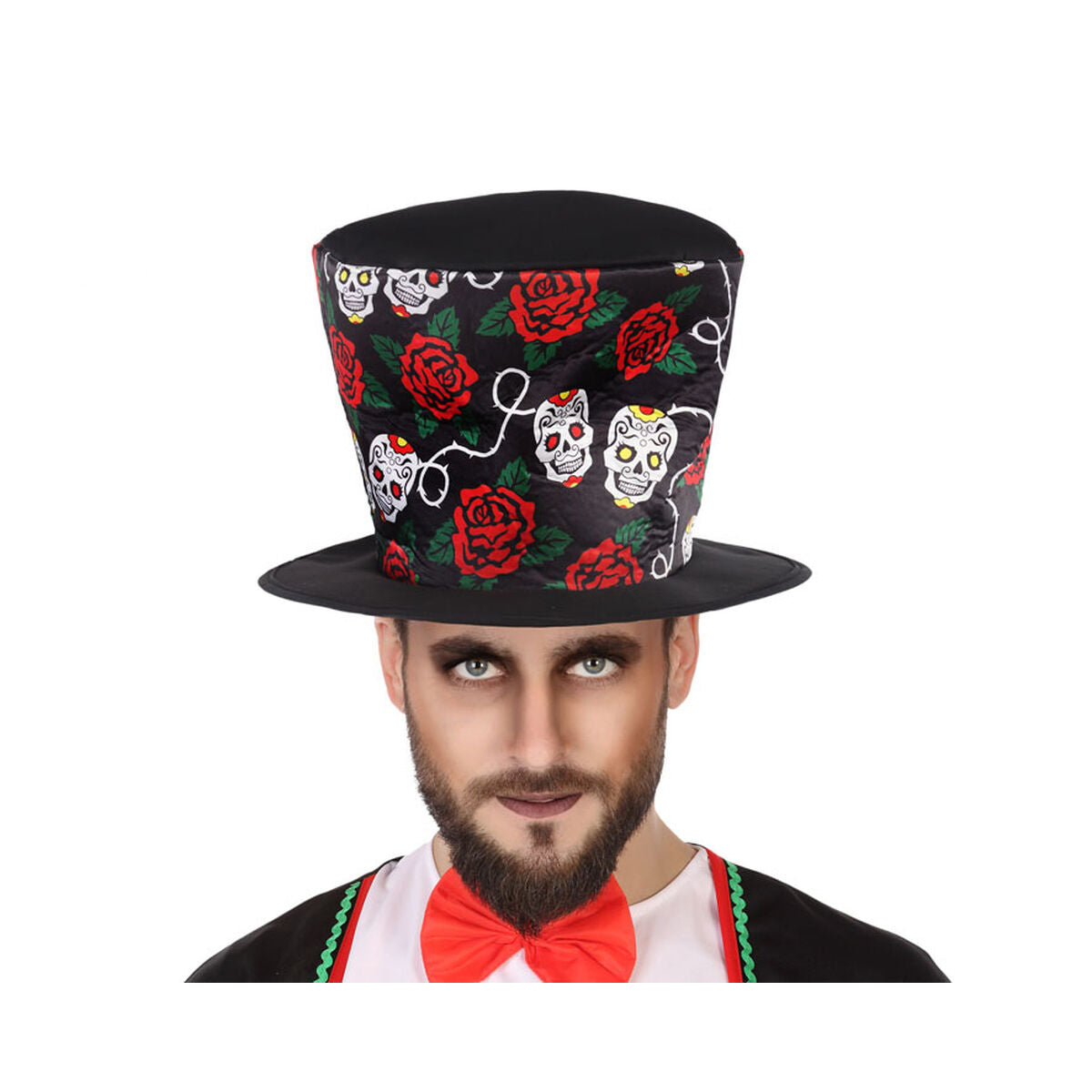 En vuxen man med skägg och mörk ögonmakeup bär en svart hög hatt dekorerad med färgglada mexikanska dödskallar (calaveras) och röda rosor.