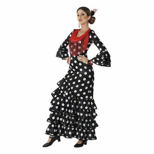 Kvinna i en helsvart, långärmad flamenco-klänning med vita prickar och stora volanger på kjolen, kompletterad med en röd fransig detalj över bröstet.