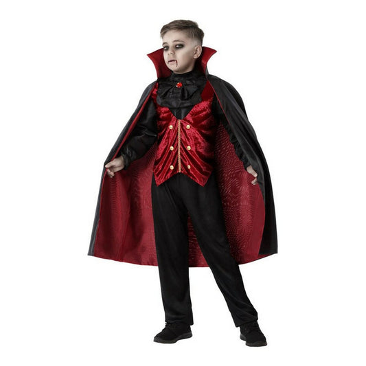En ung pojke klädd i en komplett vampyrdräkt med en svart mantel fodrad i rött, en röd sammetsväst och svarta byxor.