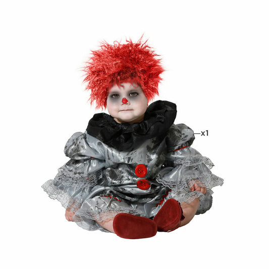 En baby klädd i en grå och silverfärgad clowndräkt med rött, yvigt hår och en röd clownnäsa. Dräkten har svarta volanger och stora röda knappar.