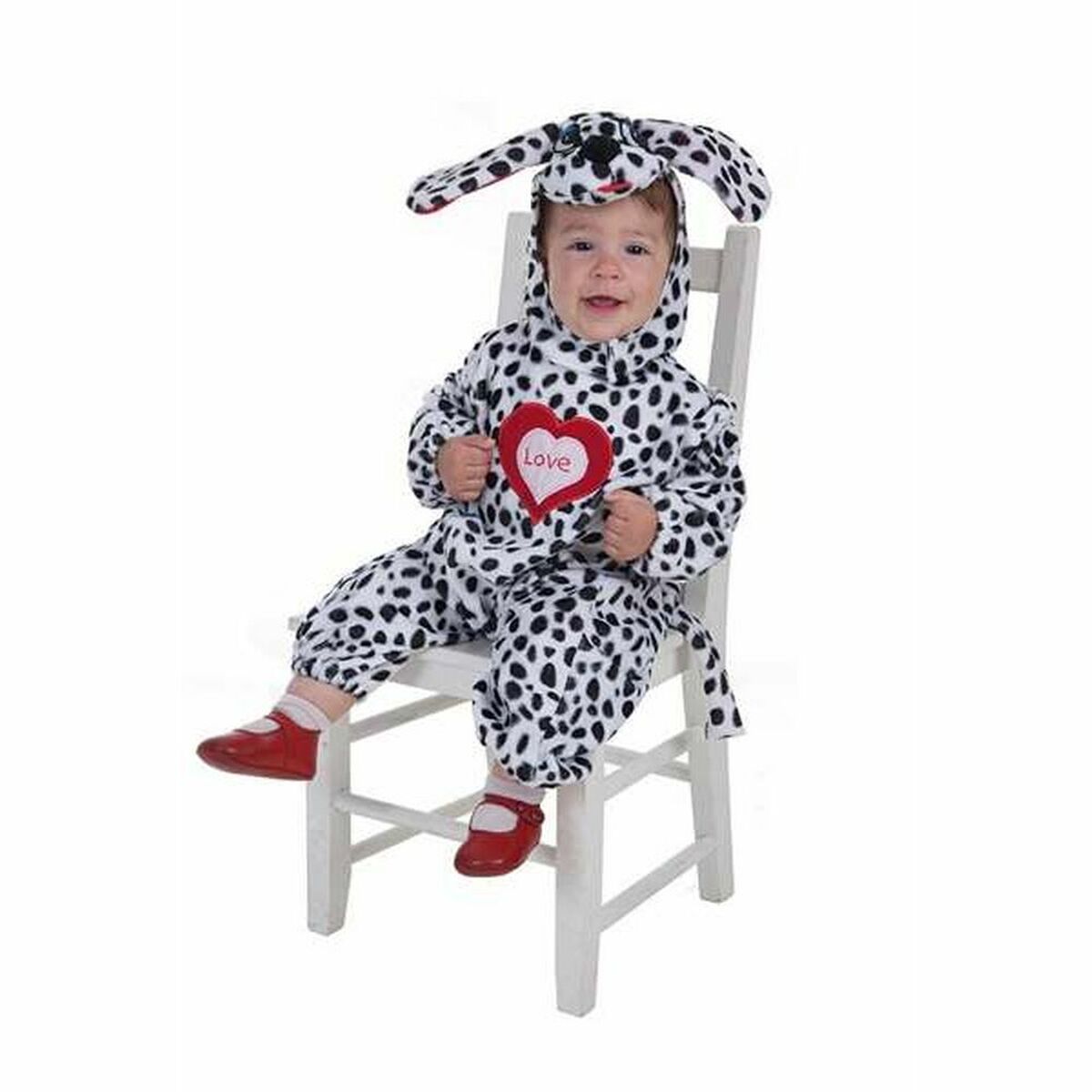 En liten bebis sitter på en vit stol klädd i en svartvit prickig dalmatinerdräkt med matchande mössa och ett rött hjärta med texten 'Love' på bröstet.
