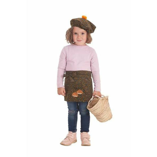 En glad liten flicka klädd i en Castañera-inspirerad maskeraddräkt som inkluderar en brun mössa med orange tofs och ett brunt förkläde med ekollon-applikationer.