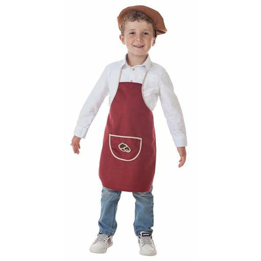 En glad liten pojke i åldern 1-2 år poserar iklädd en röd Castañero-förklädesdräkt över en vit skjorta och jeans, komplett med en brun basker.