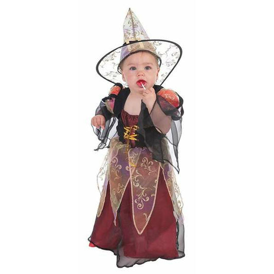 En liten bebis klädd i en detaljerad häxdräkt med röd-lila klänning och en spetsig hatt, som suger på en klubba.