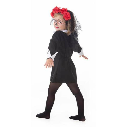 Liten flicka klädd i en svart Catrina-maskeraddräkt med röda rosor i håret och ansiktsmålning, tittandes över axeln mot kameran.