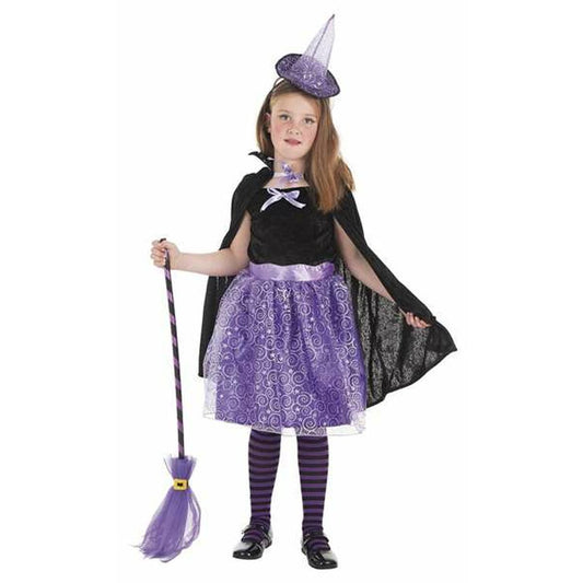 Ett barn poserar i en svart och lila häxdräkt med mantel, en virvlande kjol, randiga strumpbyxor, liten hatt och håller i en lila och svart kvast.