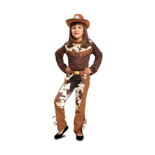 Ett ungt barn poserar iförd en komplett brun och vit cowgirl-maskeraddräkt som inkluderar byxor med koskinnstryck, en långärmad tröja med fransar och en matchande cowboyhatt.