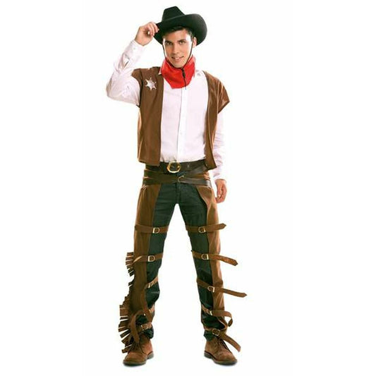 En man i en komplett brun cowboydräkt som inkluderar väst, skärp, chaps med spännen och en röd bandana, stående och ler mot kameran.