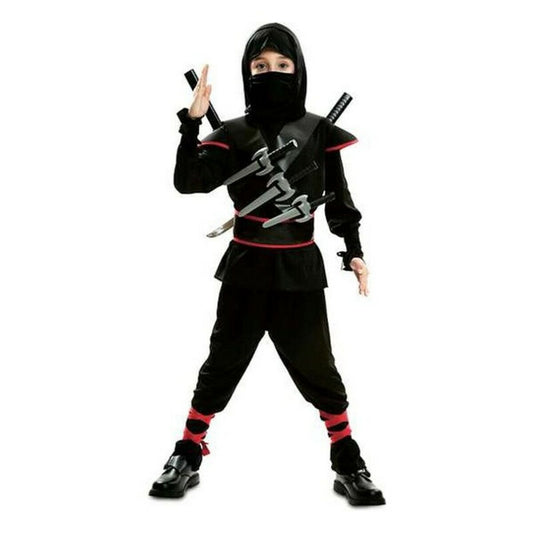 Ett barn poserar i en komplett svart ninjadräkt med röda detaljer, ansiktsmask, och utrustad med flera leksakssvärd fästa över bröstet.