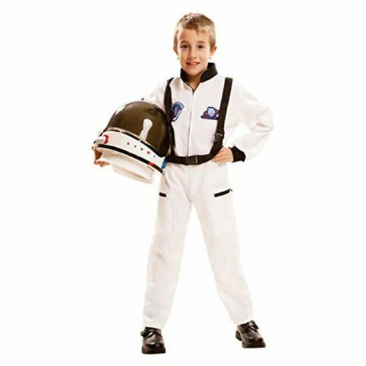 En ung pojke ler och håller en mörk astronauthjälm under armen, klädd i en vit astronautdräkt med svarta detaljer och hängslen.