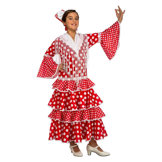 Ett barn i en röd och vit prickig flamenco-maskeraddräkt med volanger och vita axelfransar, poserar glatt.