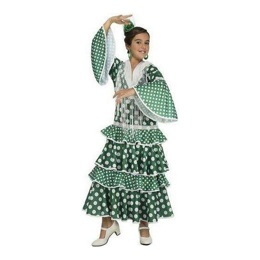 Ett glatt barn i en grön och vit prickig flamencodansdräkt med volanger och vida ärmar, poserar energiskt.
