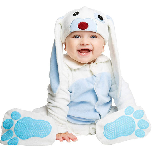 En leende baby sitter och bär en vit och ljusblå plyschdräkt med ett kaninhuvud och stora blåa kanintassar.