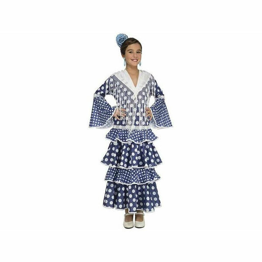 Ett leende barn i en blå och vit flamenco-maskeraddräkt med stora vita prickar och volanger på kjolen samt en blå blomma i håret.