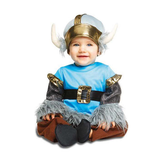 En leende bebis sitter klädd i en vikingadräkt med ett hornförsett pannband, blå överdel, bruna byxor och lurviga detaljer på ärmar och benslut.