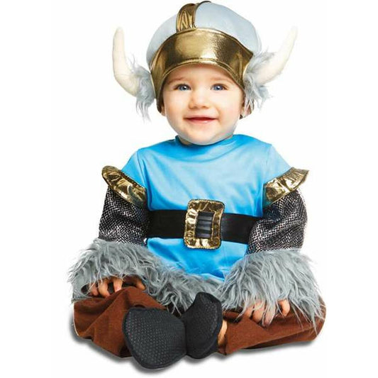 En glad baby sitter på golvet iförd en komplett vikingadräkt med hjälm, blå tröja, bruna byxor, bälte och lurviga detaljer.